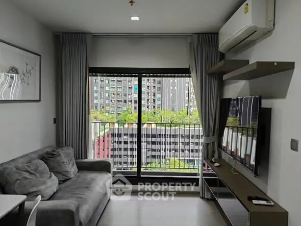Modern living room with city view, featuring a cozy sofa and wall-mounted TV.