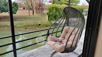 Charming balcony with cozy hanging chair overlooking serene water view