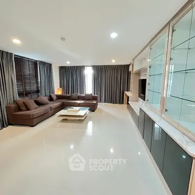 Spacious modern living room with elegant brown sofa and large windows for natural light.