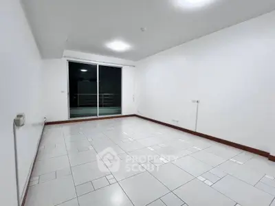 Spacious unfurnished living room with tiled flooring and balcony access.