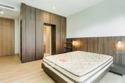 Spacious modern bedroom with wooden accents and built-in closet