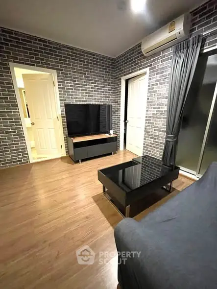 Modern living room with brick walls, sleek furniture, and wooden flooring