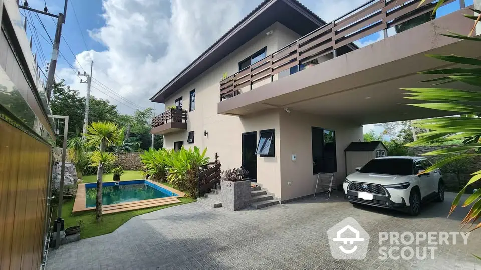 Modern two-story house with carport and pool in lush garden setting