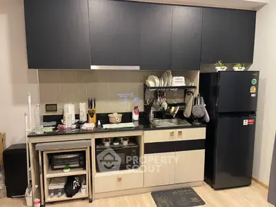 Modern kitchen with sleek cabinets, appliances, and stylish decor in a contemporary apartment.