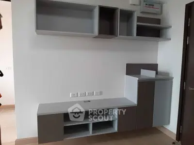 Modern minimalist living room with sleek built-in storage and neutral tones.