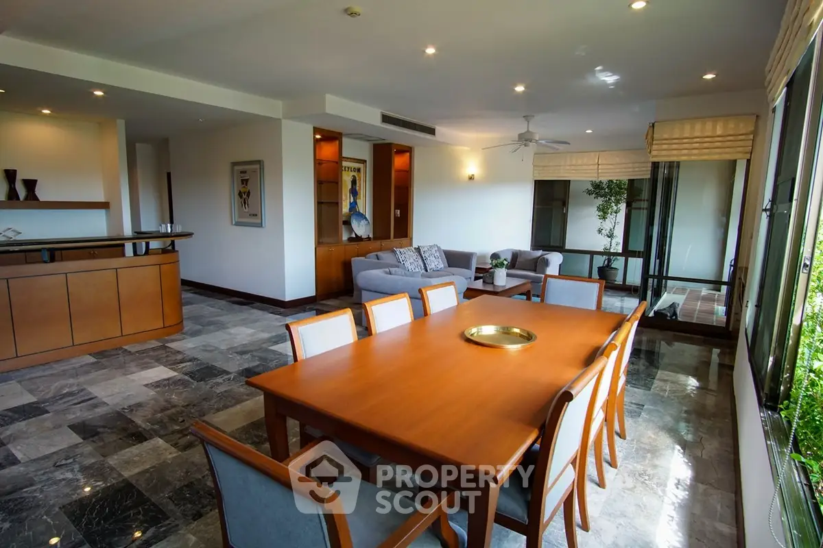 Spacious living room with elegant dining area and large windows offering natural light.