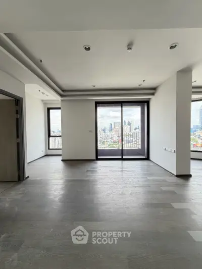 Spacious modern living room with large windows offering stunning city views, perfect for urban living.
