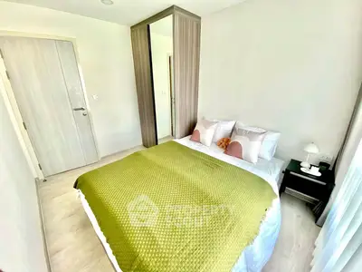 Cozy bedroom with modern decor and ample natural light, featuring a stylish wardrobe and elegant bedding.