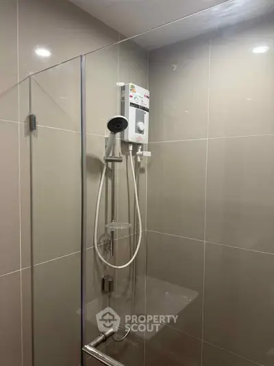 Modern bathroom with sleek shower and glass enclosure in contemporary apartment.