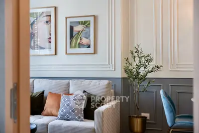 Stylish living room with modern decor, featuring a cozy sofa, chic wall art, and elegant paneling.