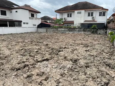 Vacant land plot in residential area with neighboring houses