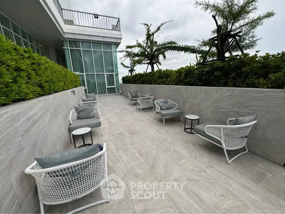 Luxurious rooftop terrace with modern seating and lush greenery, perfect for relaxation and entertaining.
