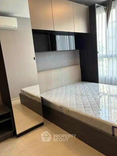 Modern bedroom with sleek design, featuring a comfortable bed and ample storage space.