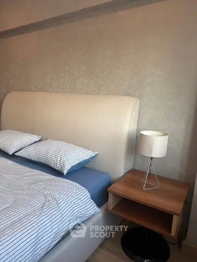Cozy bedroom with modern bed and stylish lamp on wooden nightstand