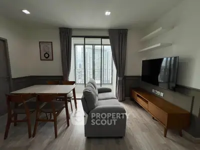 Modern living room with stylish furniture and large window offering city view