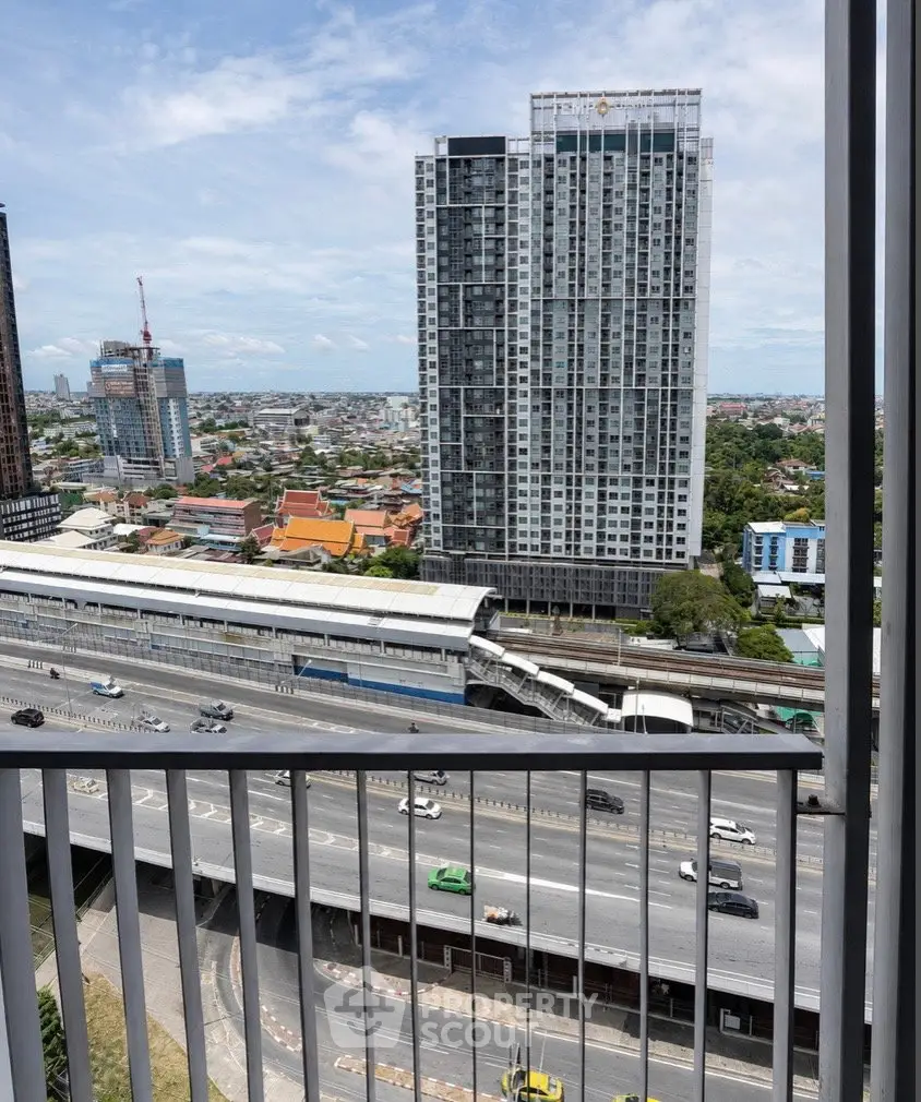 Stunning high-rise building view from balcony overlooking cityscape and highway, perfect urban living.