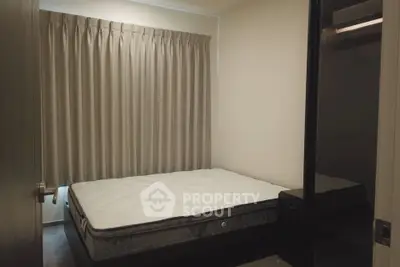 Cozy bedroom with a comfortable bed and elegant curtains, perfect for restful nights.