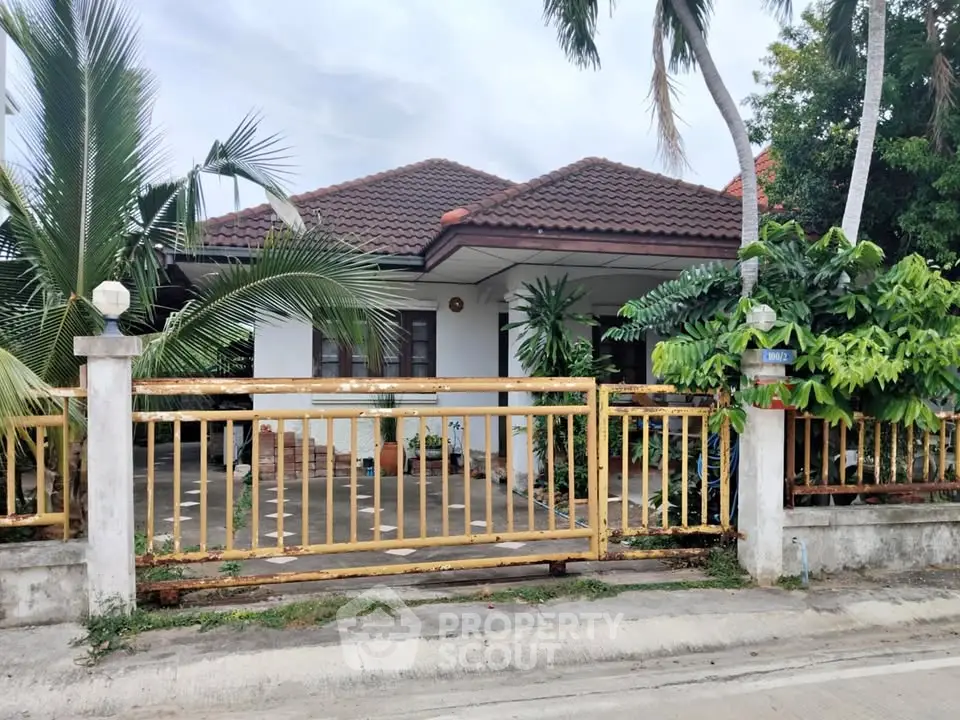 Charming single-story house with lush garden and gated entrance, perfect for serene living.