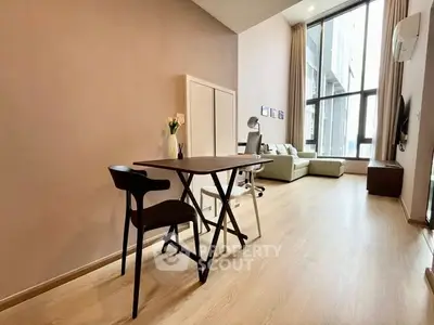 Spacious modern living room with high ceilings and large windows in a stylish apartment.