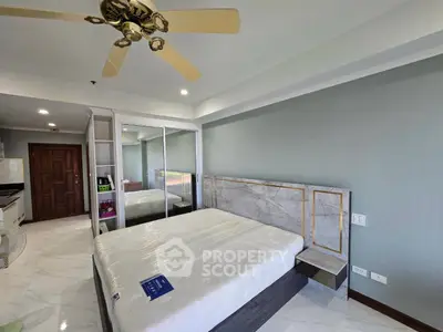 Spacious bedroom with modern design and mirrored wardrobe in a luxury apartment.