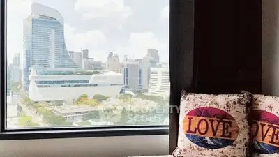 Stunning cityscape view from modern apartment window with cozy decor.