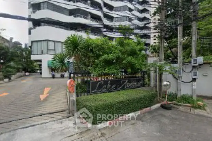 Modern apartment building with lush green landscaping and contemporary design.