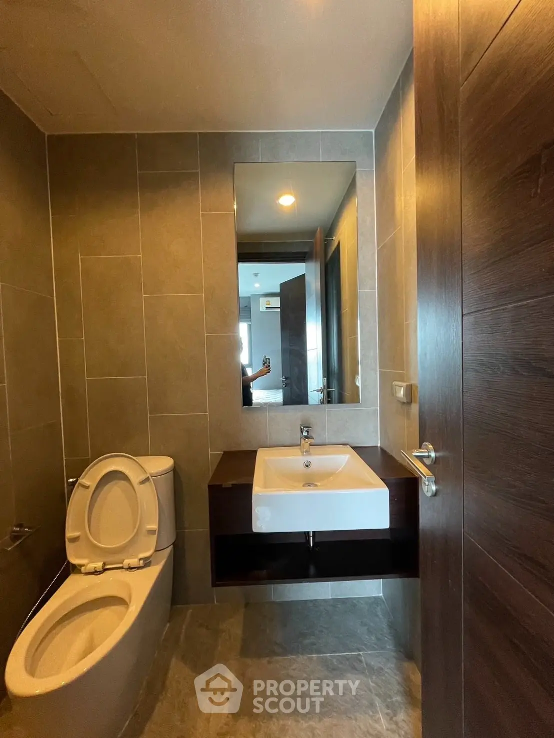 Modern bathroom with sleek fixtures and large mirror in contemporary apartment.