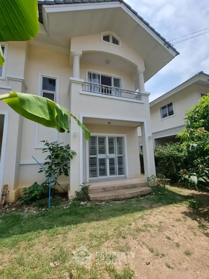 Charming two-story house with lush garden and elegant balcony, perfect for family living.