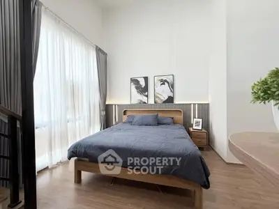 Modern bedroom with stylish decor and large window for natural light