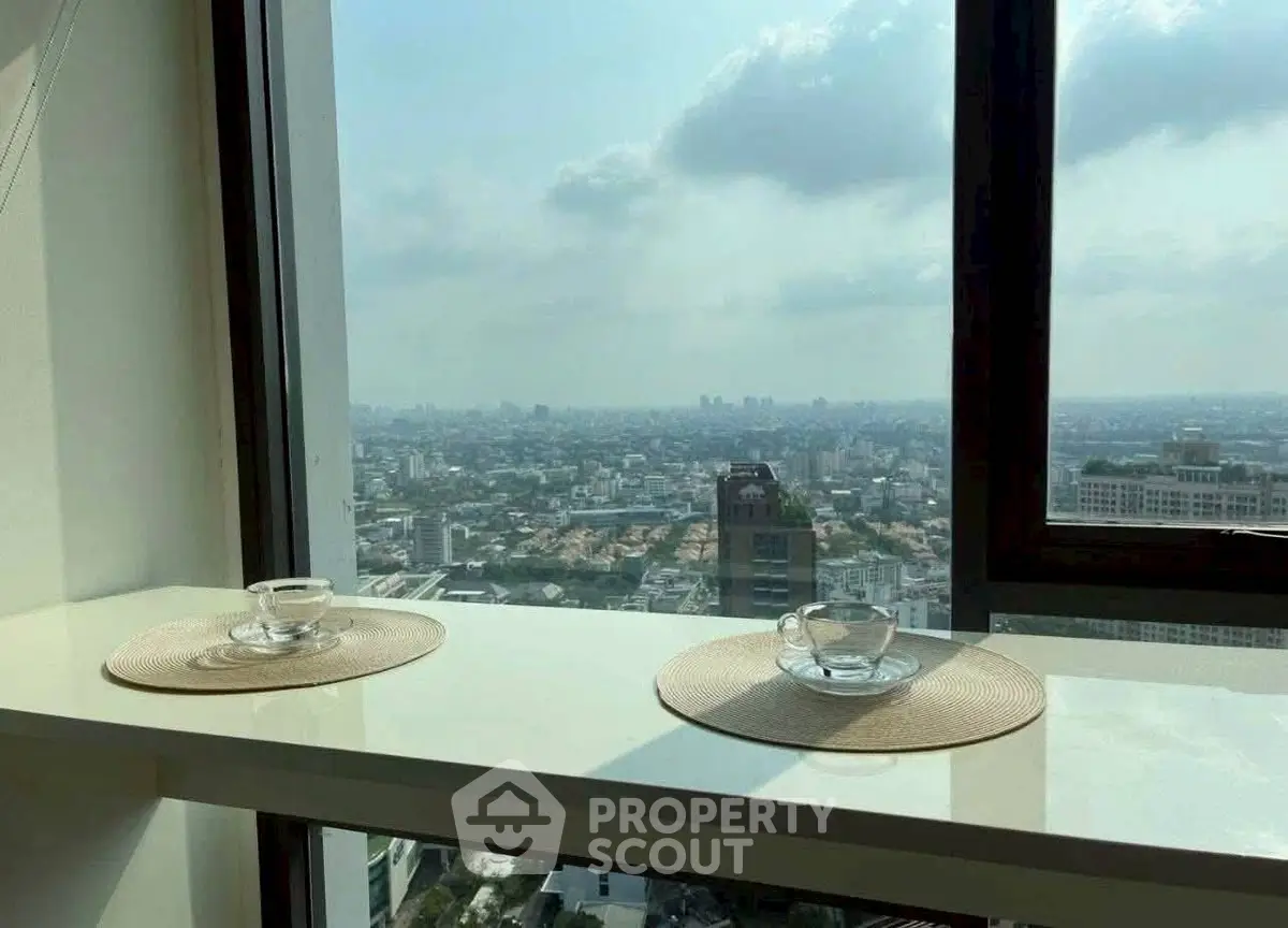 Stunning cityscape view from a high-rise apartment window with elegant decor.