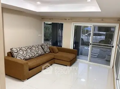 Spacious living room with modern sofa and large windows for natural light.