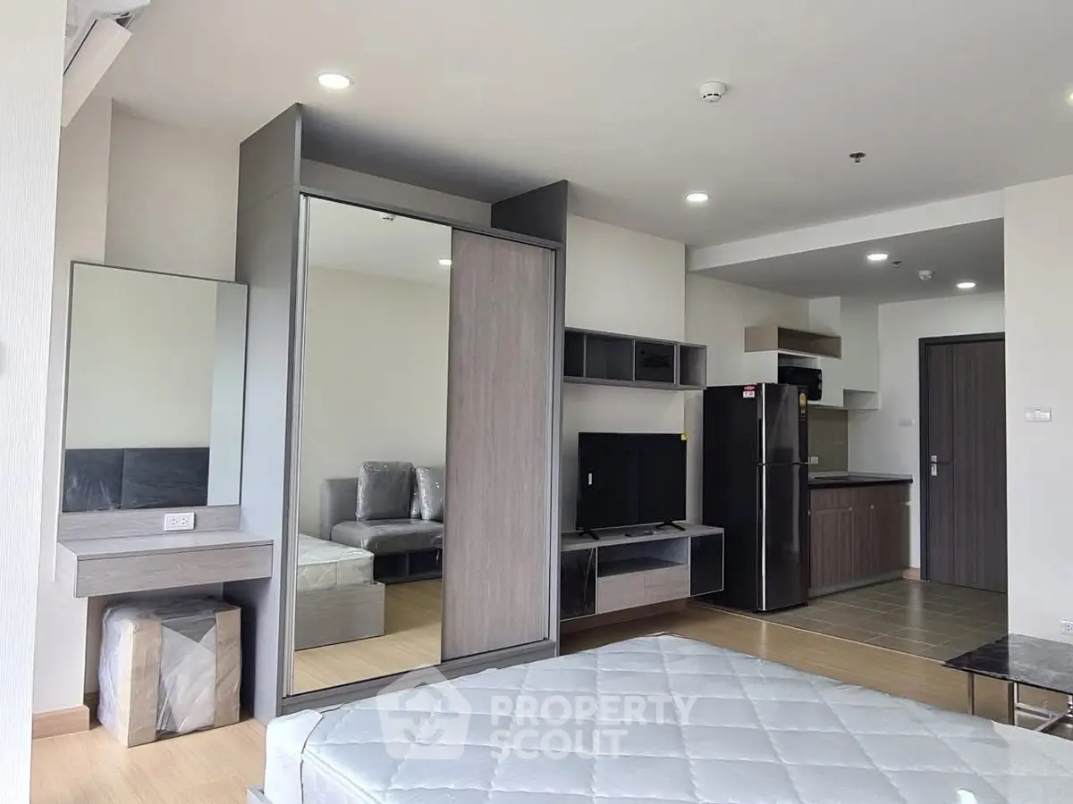 Modern studio apartment with sleek furniture and open kitchen layout, perfect for urban living.