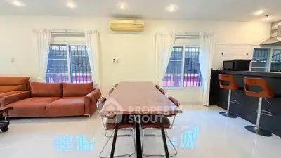Spacious modern living room with dining area and sleek kitchen bar, perfect for entertaining.