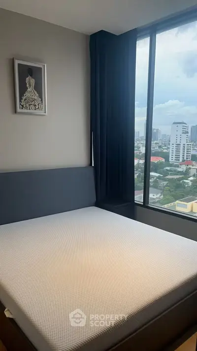 Modern bedroom with large window offering stunning city view