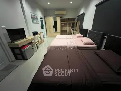 Spacious bedroom with twin beds and modern decor for comfortable living.
