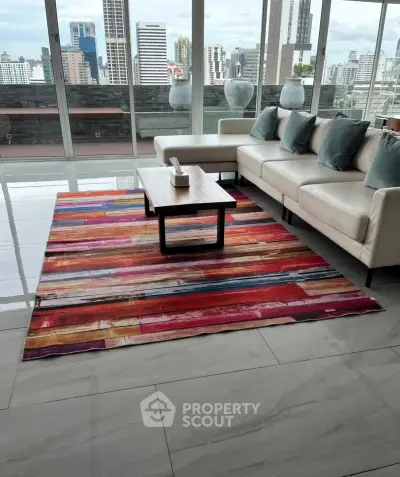 Spacious living room with modern decor and stunning city view from large windows.