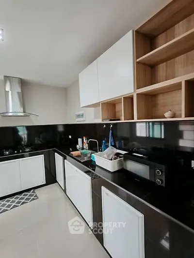 Modern kitchen with sleek black and white cabinetry and built-in appliances