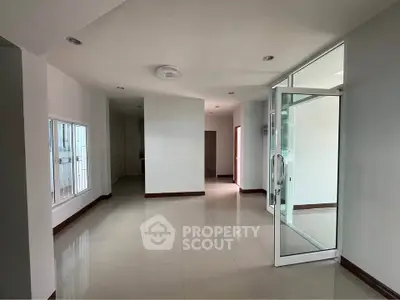 Spacious modern interior with large windows and glass door, perfect for natural light.