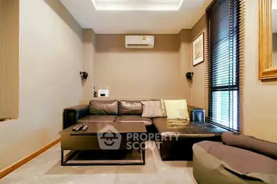 Cozy living room with modern leather sofa and air conditioning, perfect for relaxation.