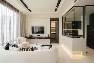 Luxurious modern living room with open kitchen, elegant decor, and natural light.