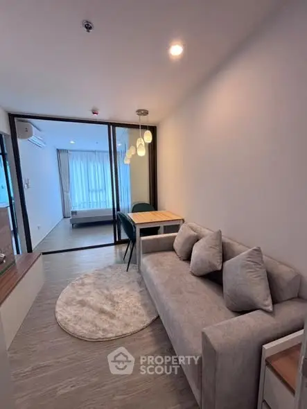 Modern living room with cozy sofa and stylish lighting in open-plan apartment.