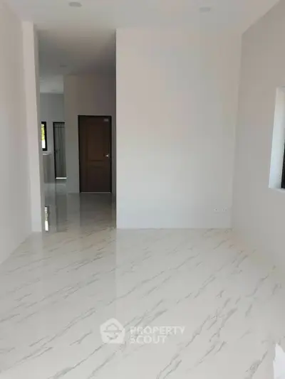 Spacious modern interior with sleek marble flooring and neutral walls, perfect for customization.