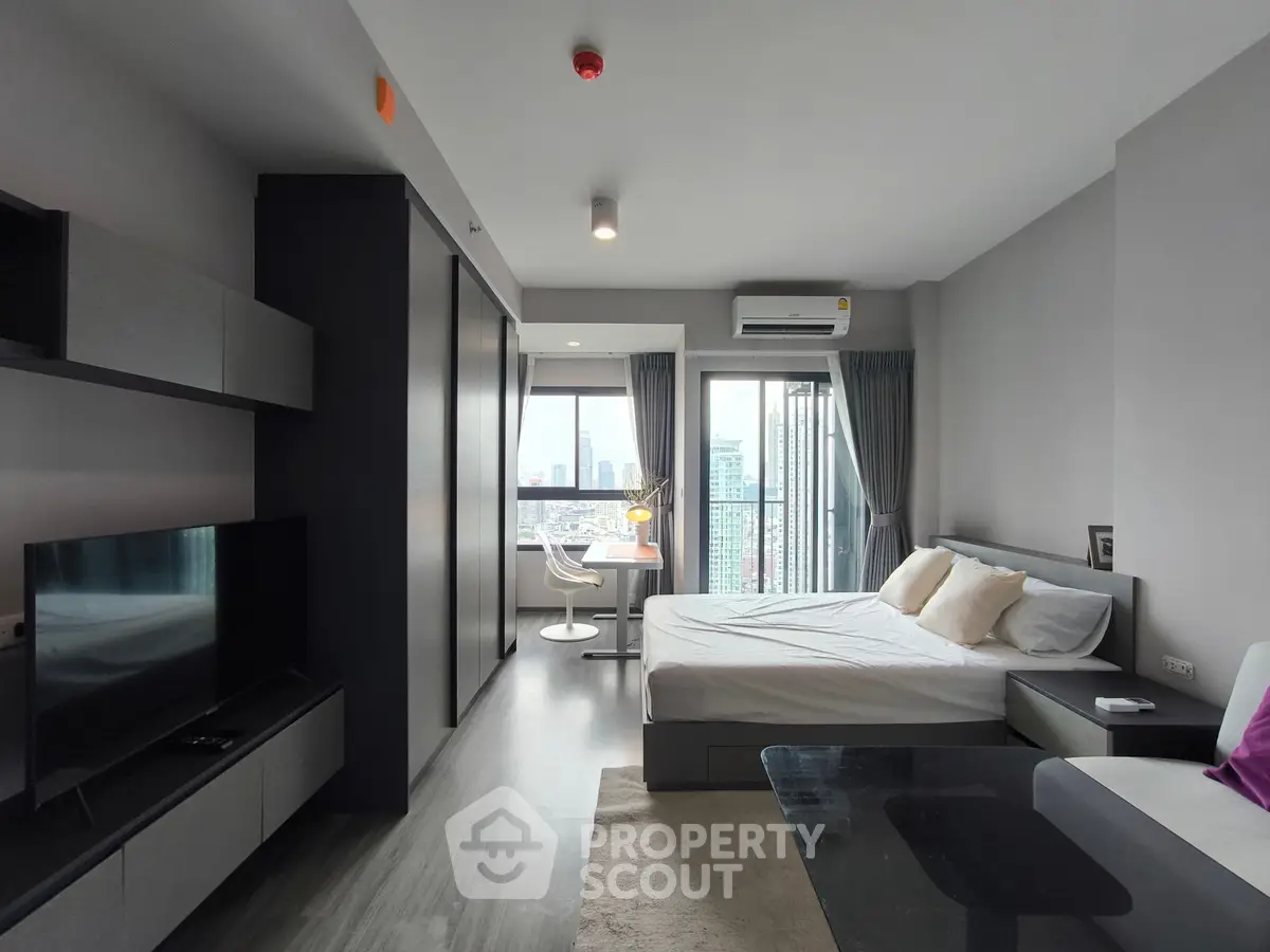 Modern studio apartment with city view, featuring sleek furniture and a cozy ambiance.