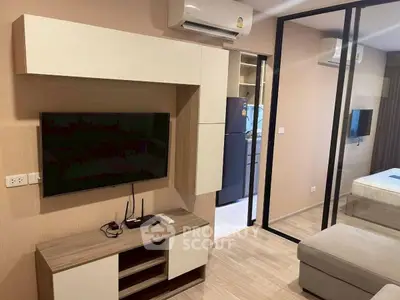 Modern living room with sleek furniture and open view into bedroom, featuring air conditioning and stylish decor.