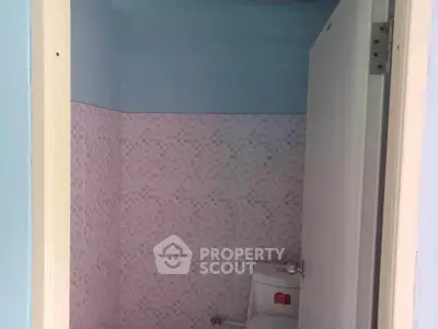 Compact bathroom with pastel tile design and modern fixtures