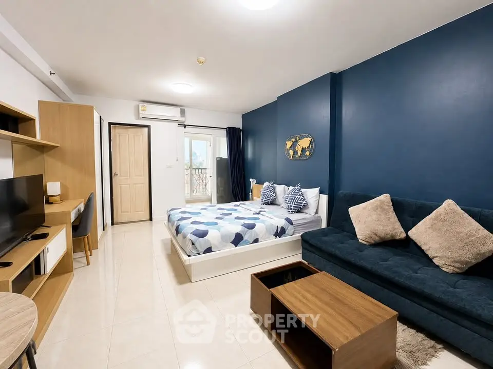 Modern studio apartment with stylish decor and cozy furnishings, featuring a comfortable bed and a sleek sofa.