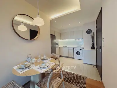 Modern open kitchen with dining area, featuring sleek appliances and elegant decor.