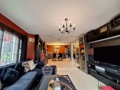 Elegant living room with chandelier and modern decor, featuring a spacious open layout and stylish furnishings.