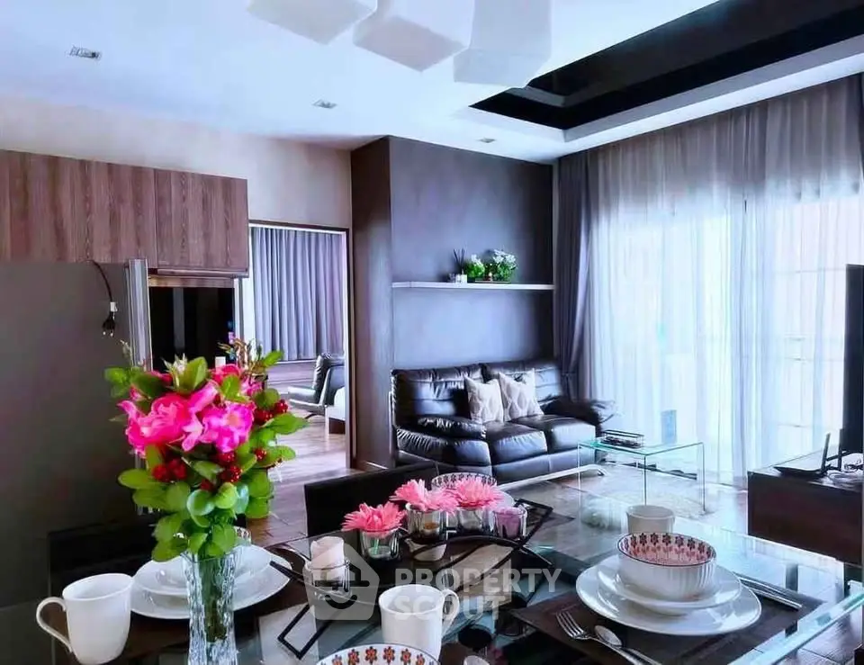 Modern living room with elegant decor and large windows offering natural light.