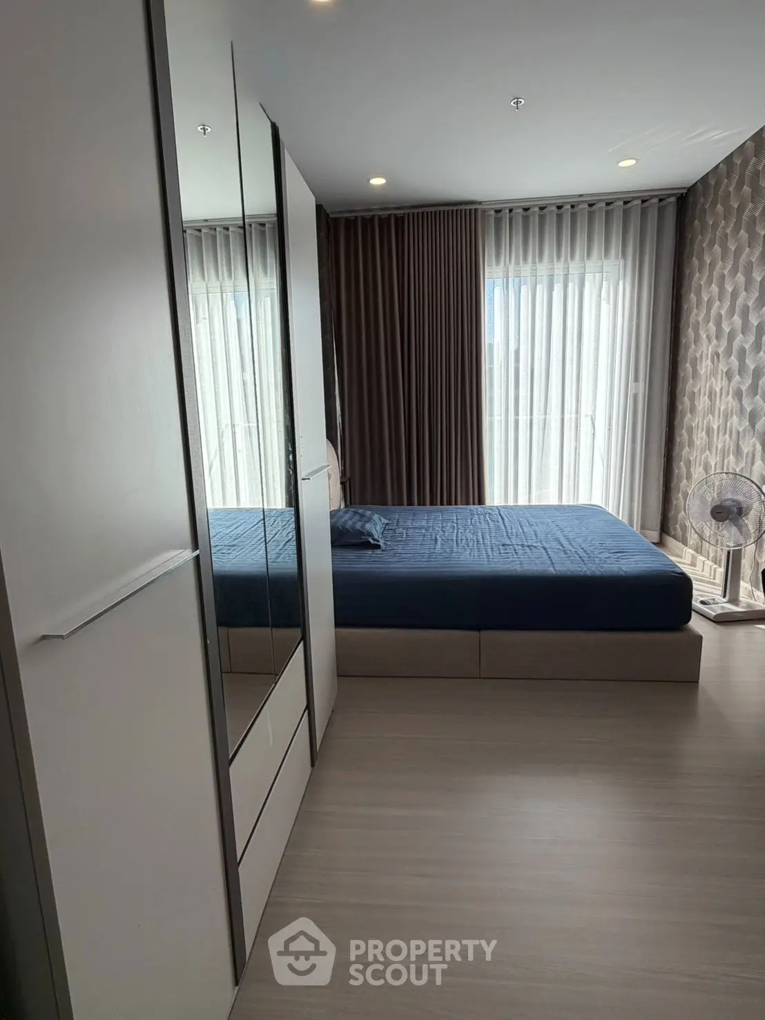 Modern bedroom with sleek design and large window for natural light.